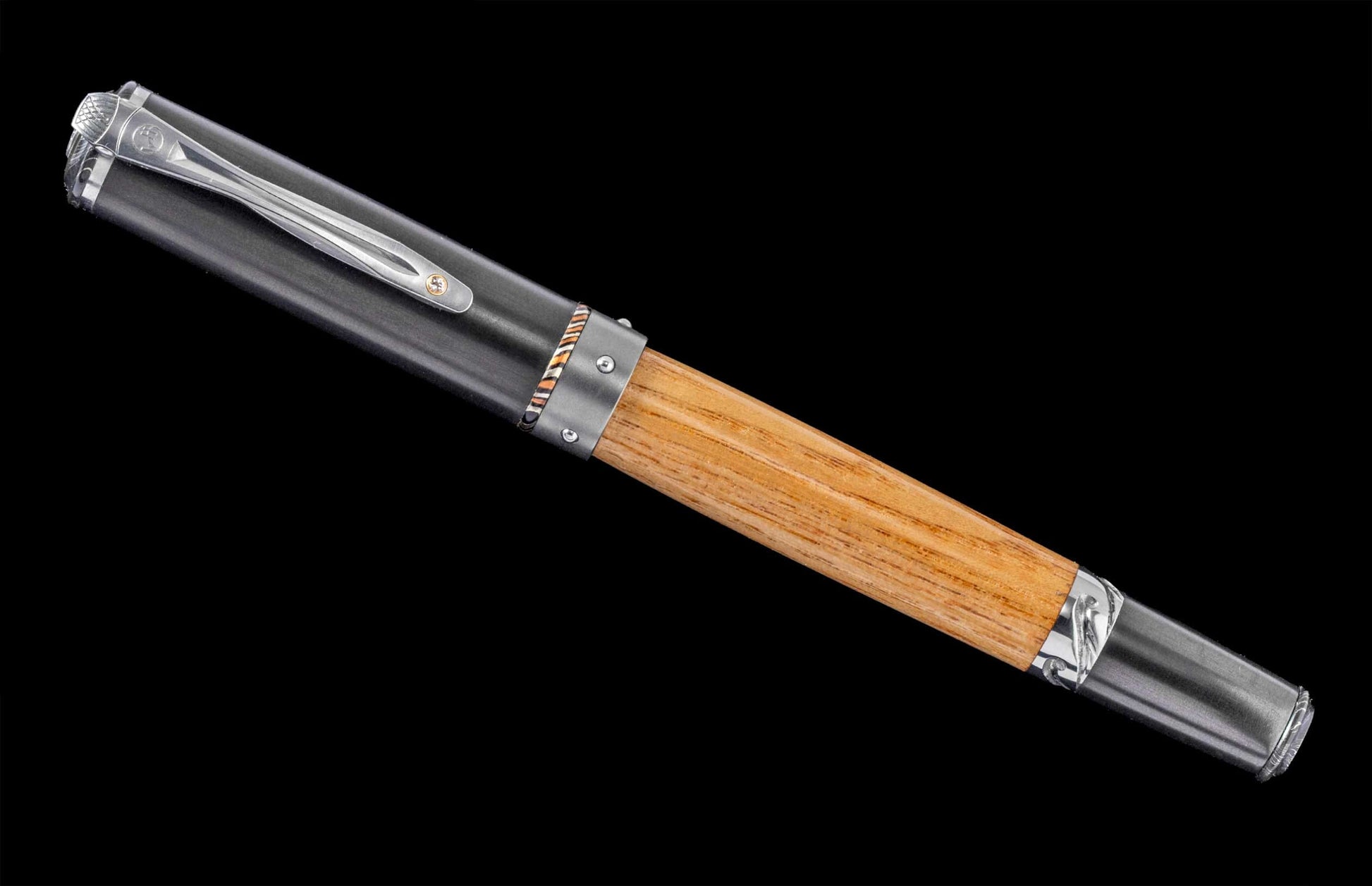 Handcrafted pen from William Henry pen featuring a barrel of cherry wood from Churchill Downs backside stable floors, titanium and aluminum, carbon fiber, mokume, sterling silver, and a white topaz gemstone.